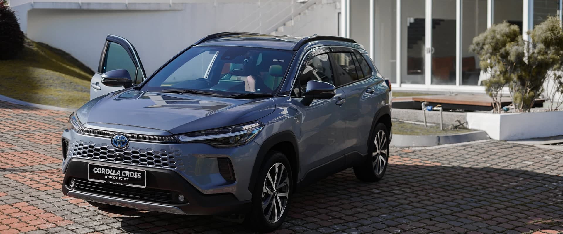 Toyota Corolla Cross warna merah, pandangan sisi tiga suku