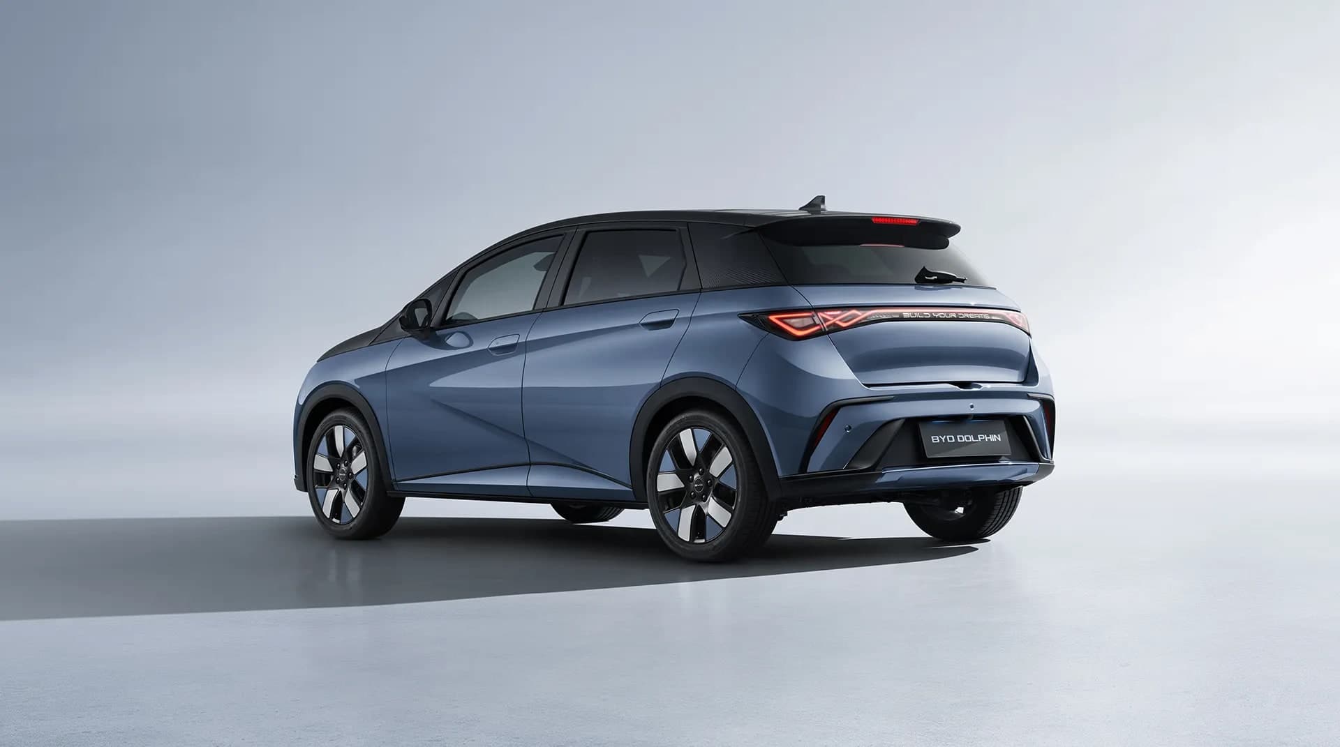 BYD Dolphin warna biru dengan bumbung hitam, pandangan belakang tiga suku