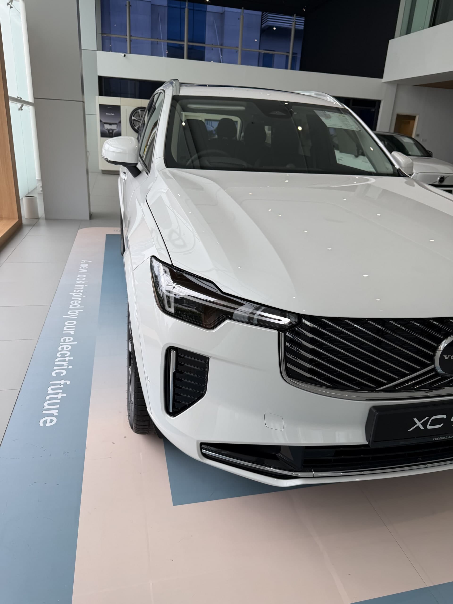 Bahagian hadapan Volvo XC90 T8 plug-in hybrid warna putih dari sudut kiri, menunjukkan gril dan lampu Thor Hammer