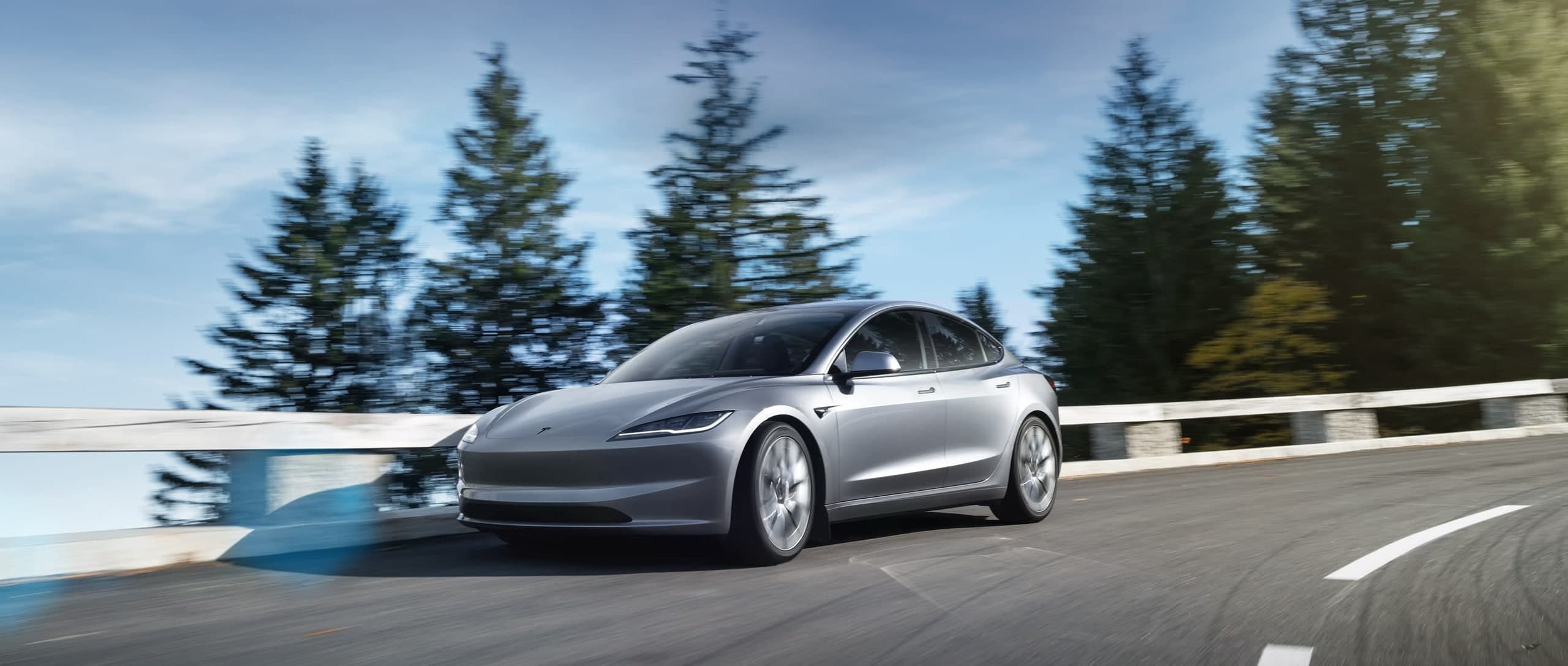 Tesla Model 3 warna kelabu, memandu di jalan gunung