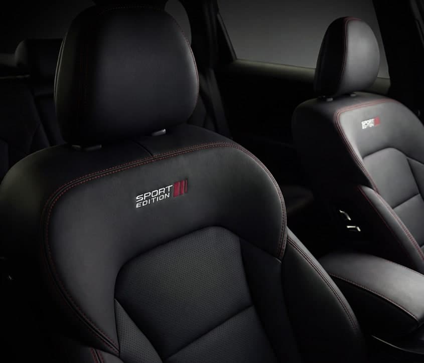 Tempat duduk Proton X70 Sport Edition dengan jahitan merah dan logo SE