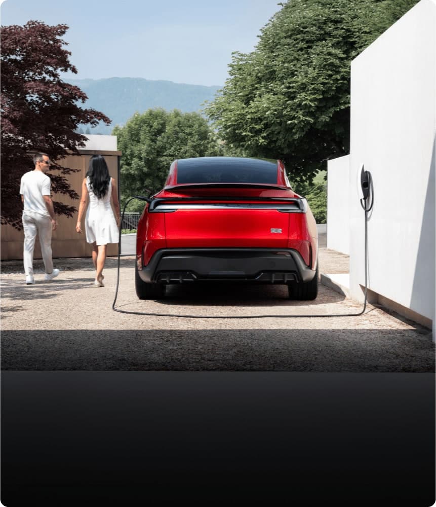 Tesla Model Y warna merah, mengecas di rumah