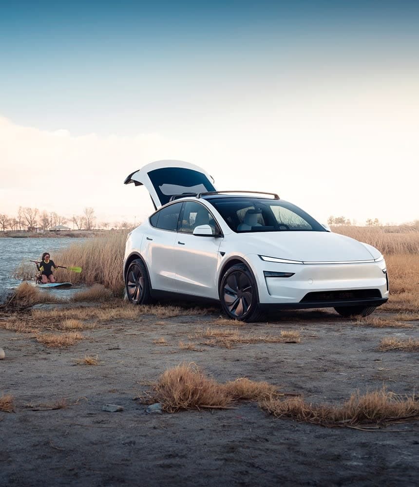 Tesla Model Y warna putih, but belakang terbuka di tepi tasik