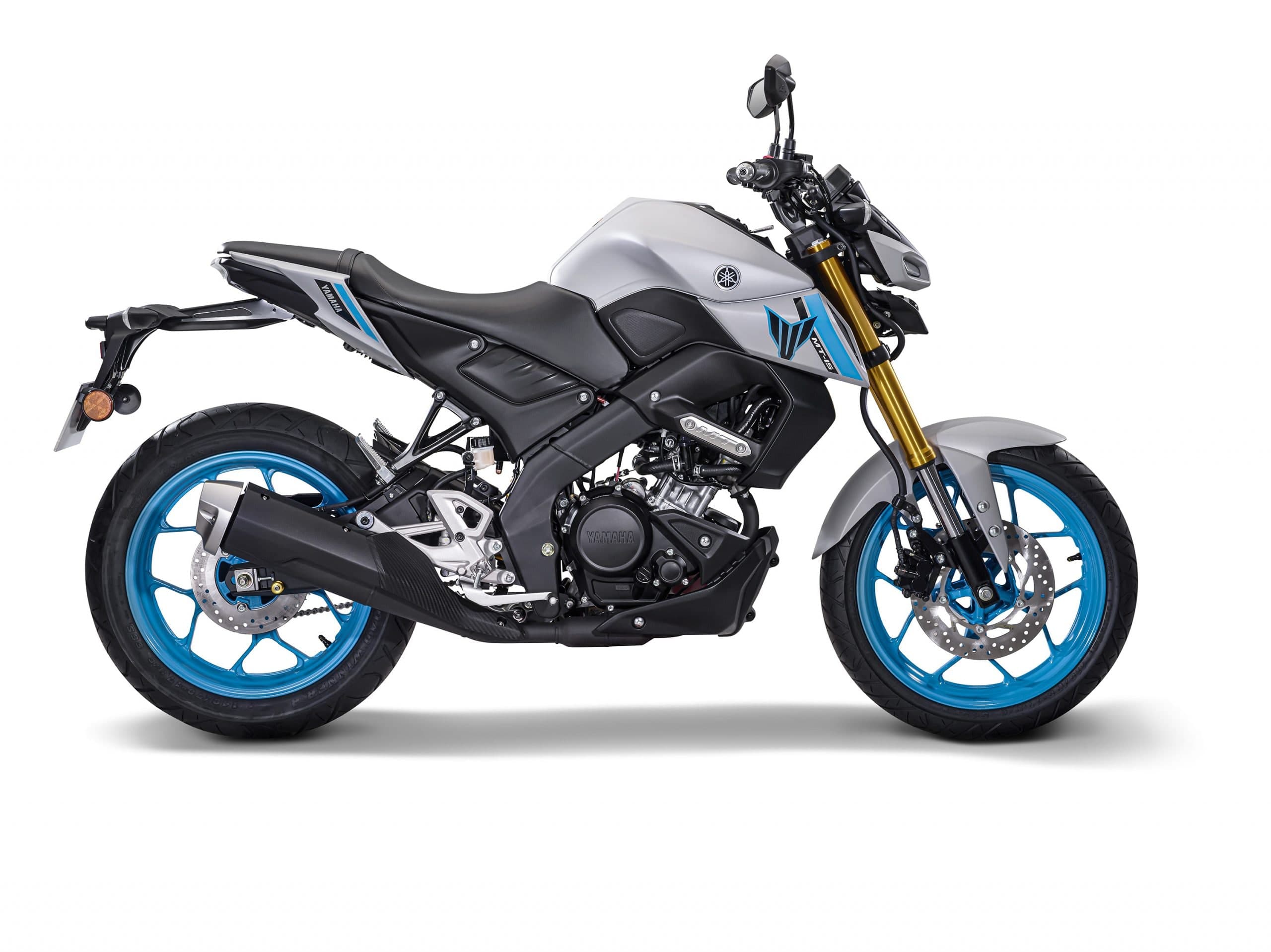 Yamaha MT-15 warna kelabu perak matte, pandangan sisi kiri penuh dengan rim biru sian dan garpu hadapan terbalik emas