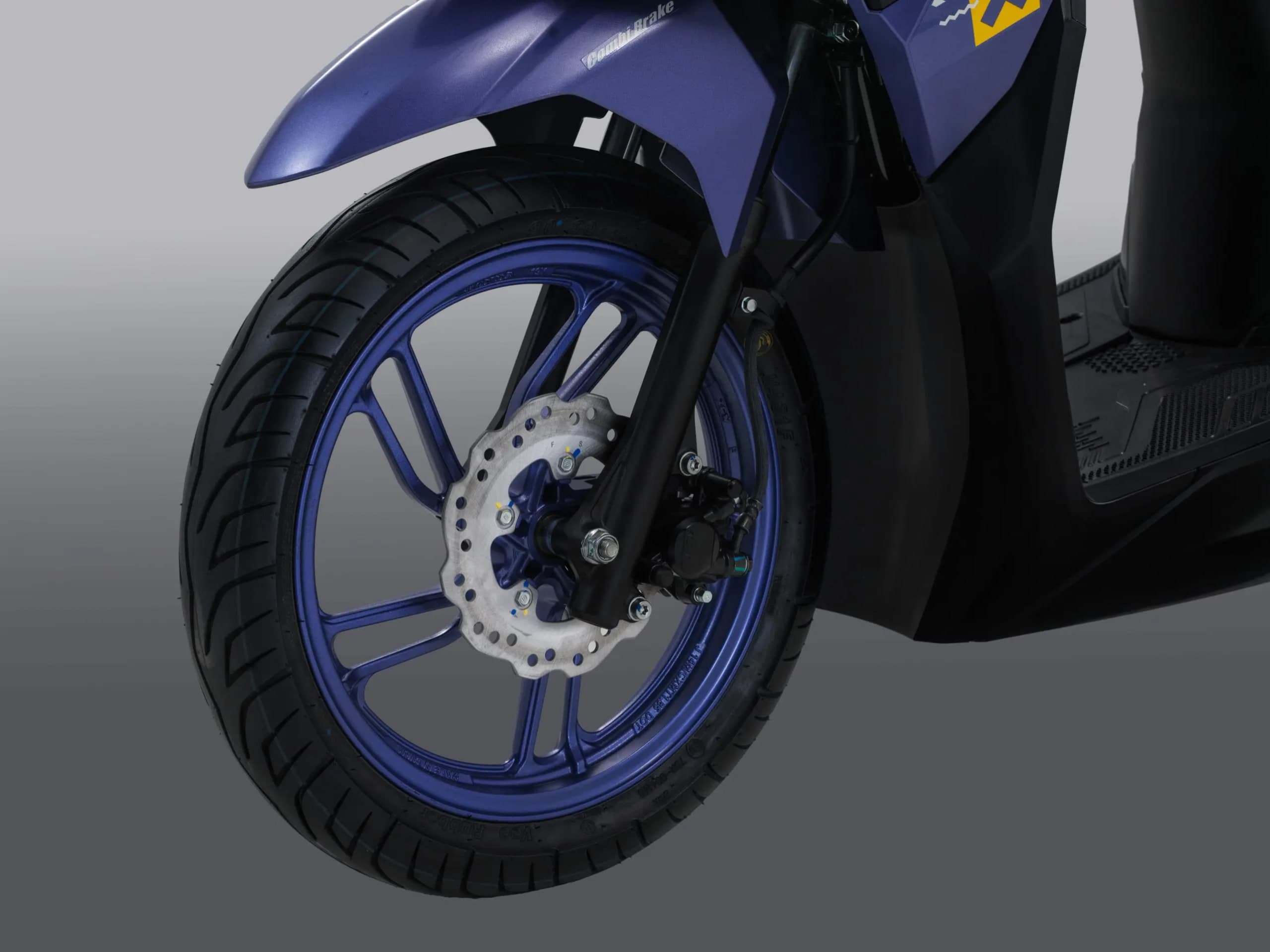 Roda hadapan dan kaliper brek cakera Honda Vario 125 Street warna biru, lencana Combi Brake kelihatan