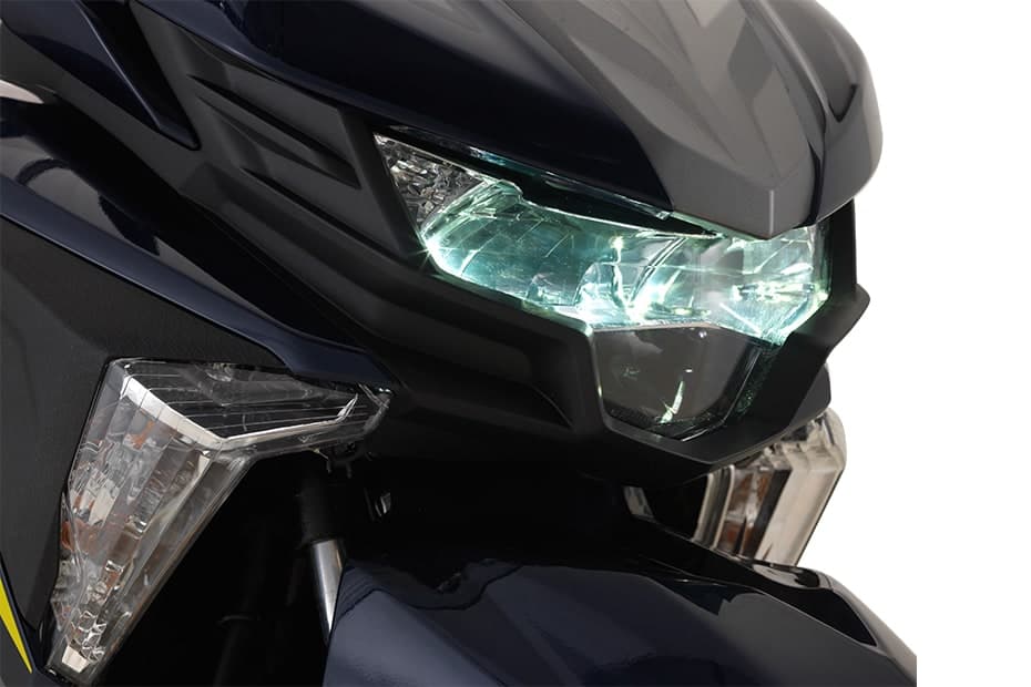 Lampu utama LED Yamaha Ego Avantiz menyala pada badan biru gelap, lampu isyarat hadapan di sebelahnya