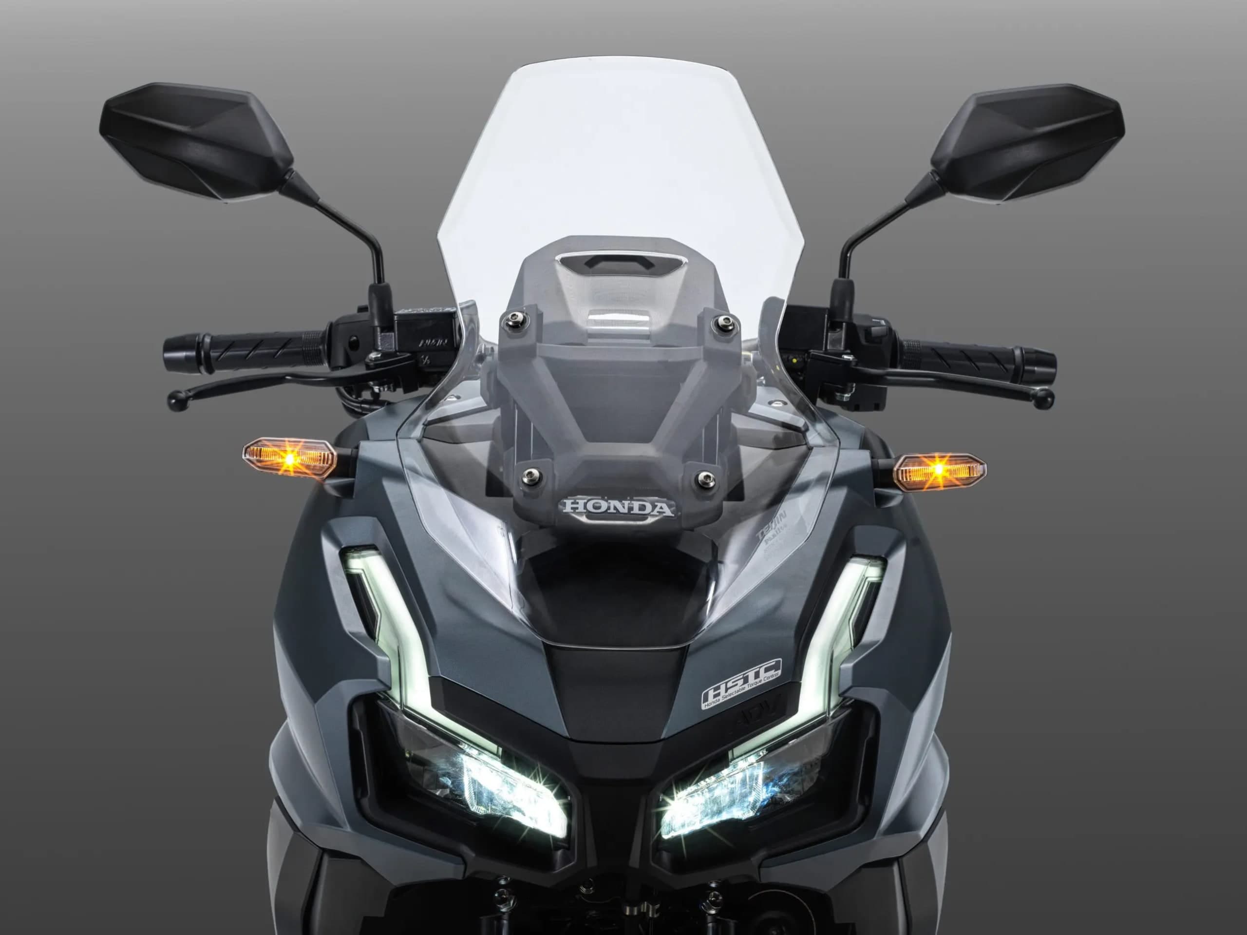 Lampu utama LED Honda ADV160 dilihat dari hadapan, cermin depan dan lencana HSTC kelihatan