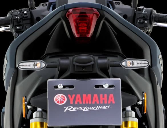 Bahagian belakang Yamaha NVX dengan lampu belakang LED merah menyala dan pemegang plat nombor bertulis Yamaha Revs Your Heart