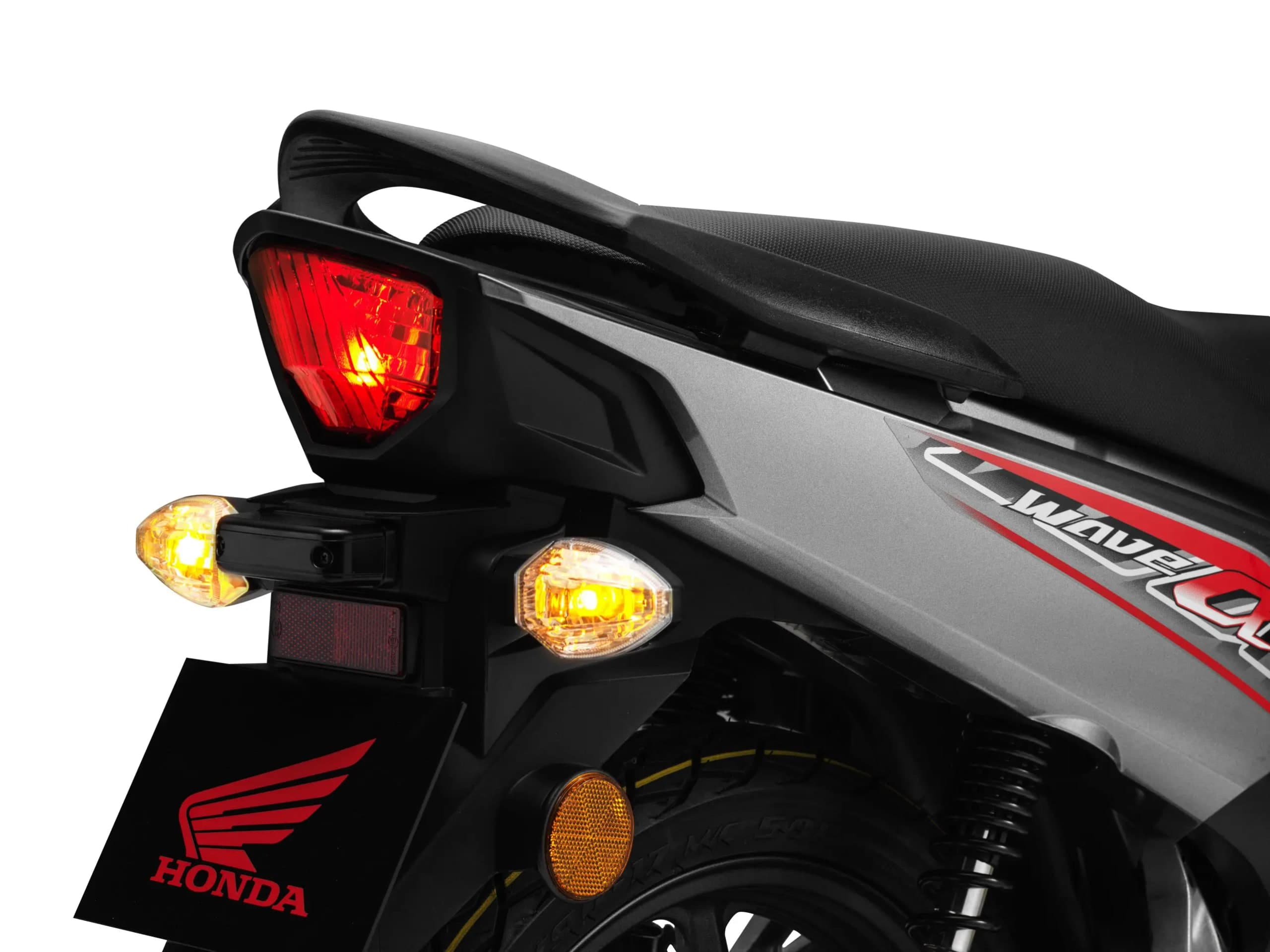 Bahagian belakang Honda Wave Alpha, lampu belakang LED merah menyala dan lampu isyarat kuning di kiri kanan