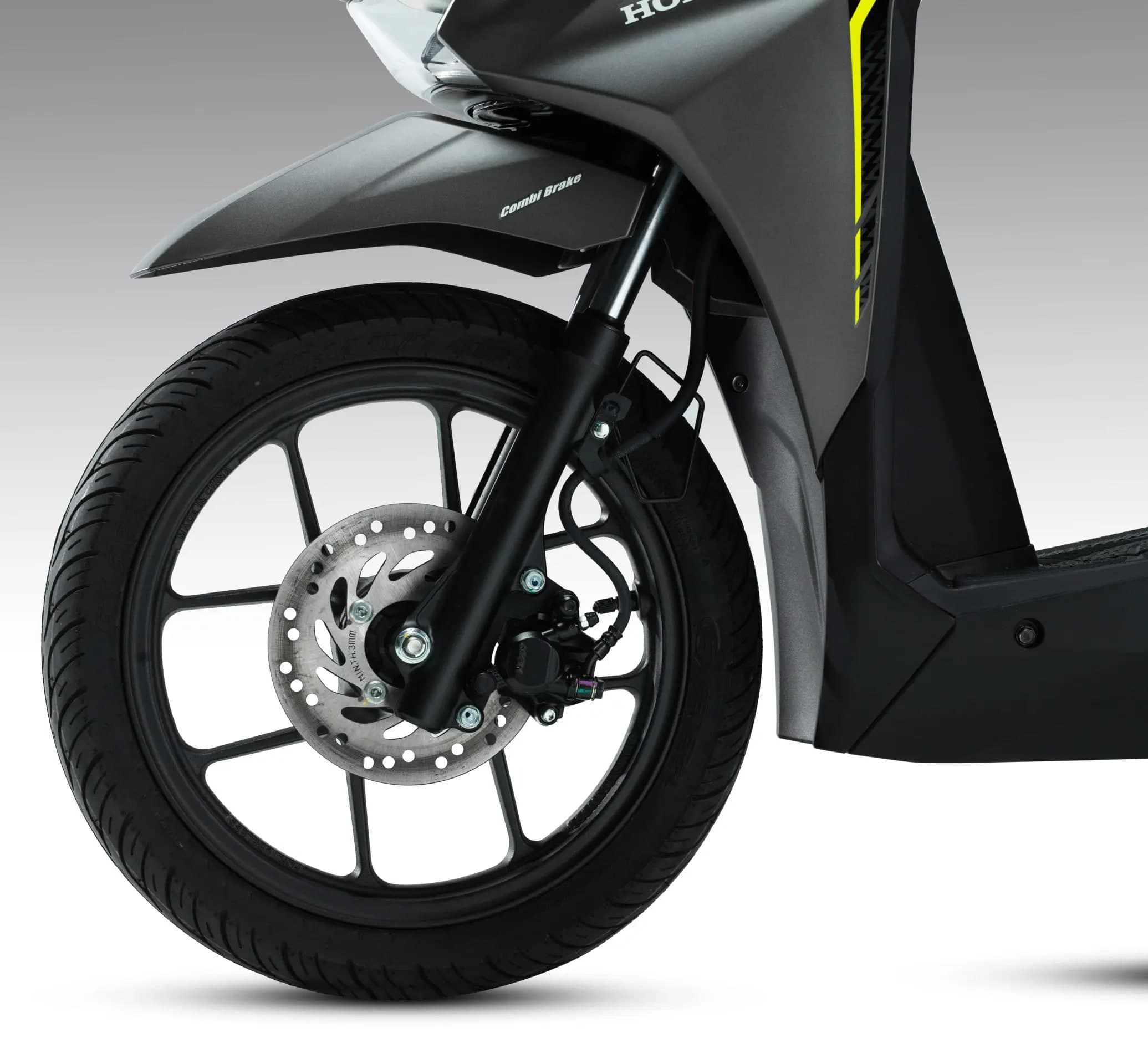 Roda hadapan Honda BeAT dengan brek cakera dan tulisan Combi Brake pada fender kelabu gelap beraksen hijau lime